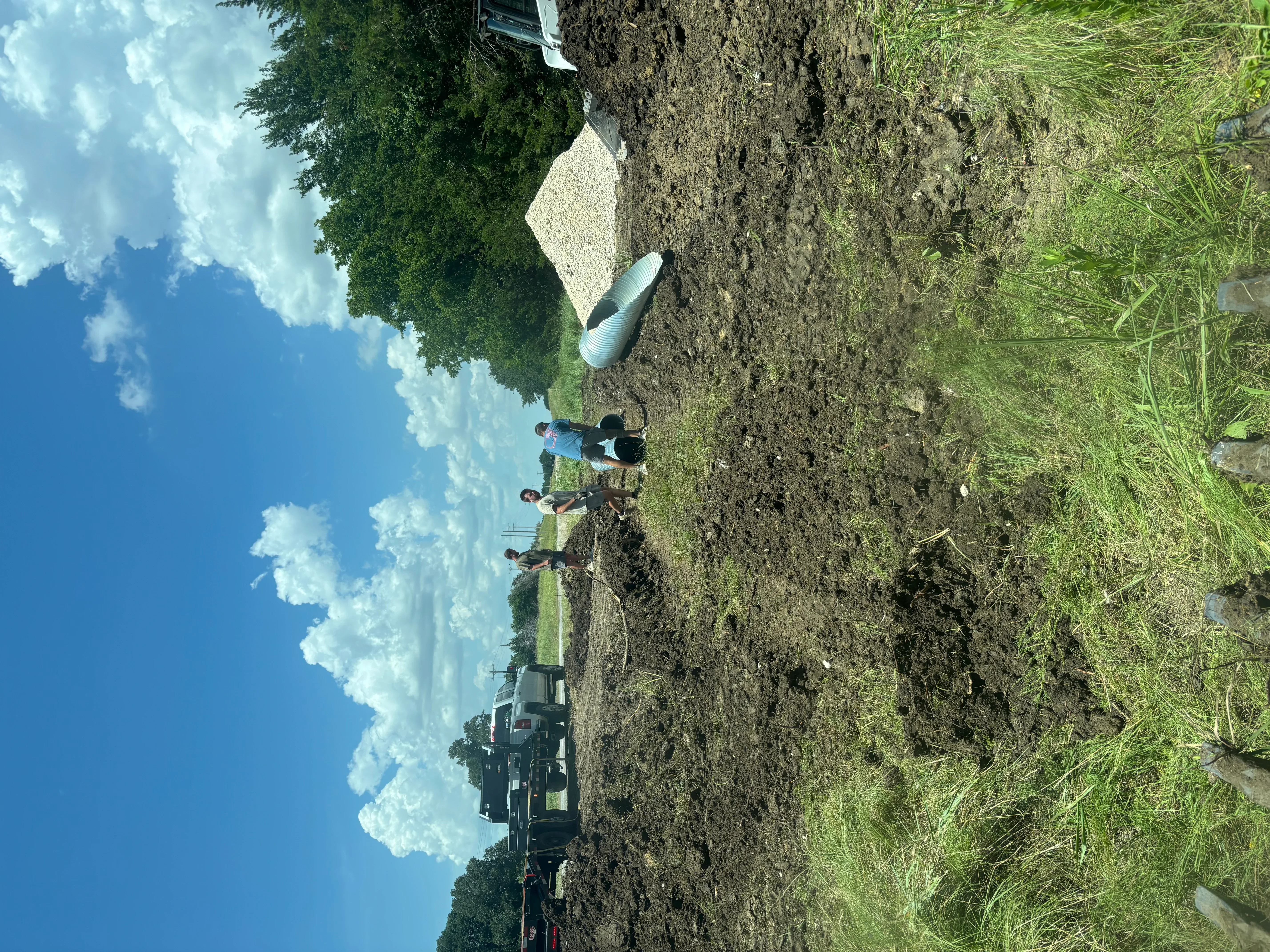 Concrete foundation footer installed in excavated soil with drainage pipe and prepared base