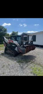 Compact track loader on gravel site for foundation excavation work