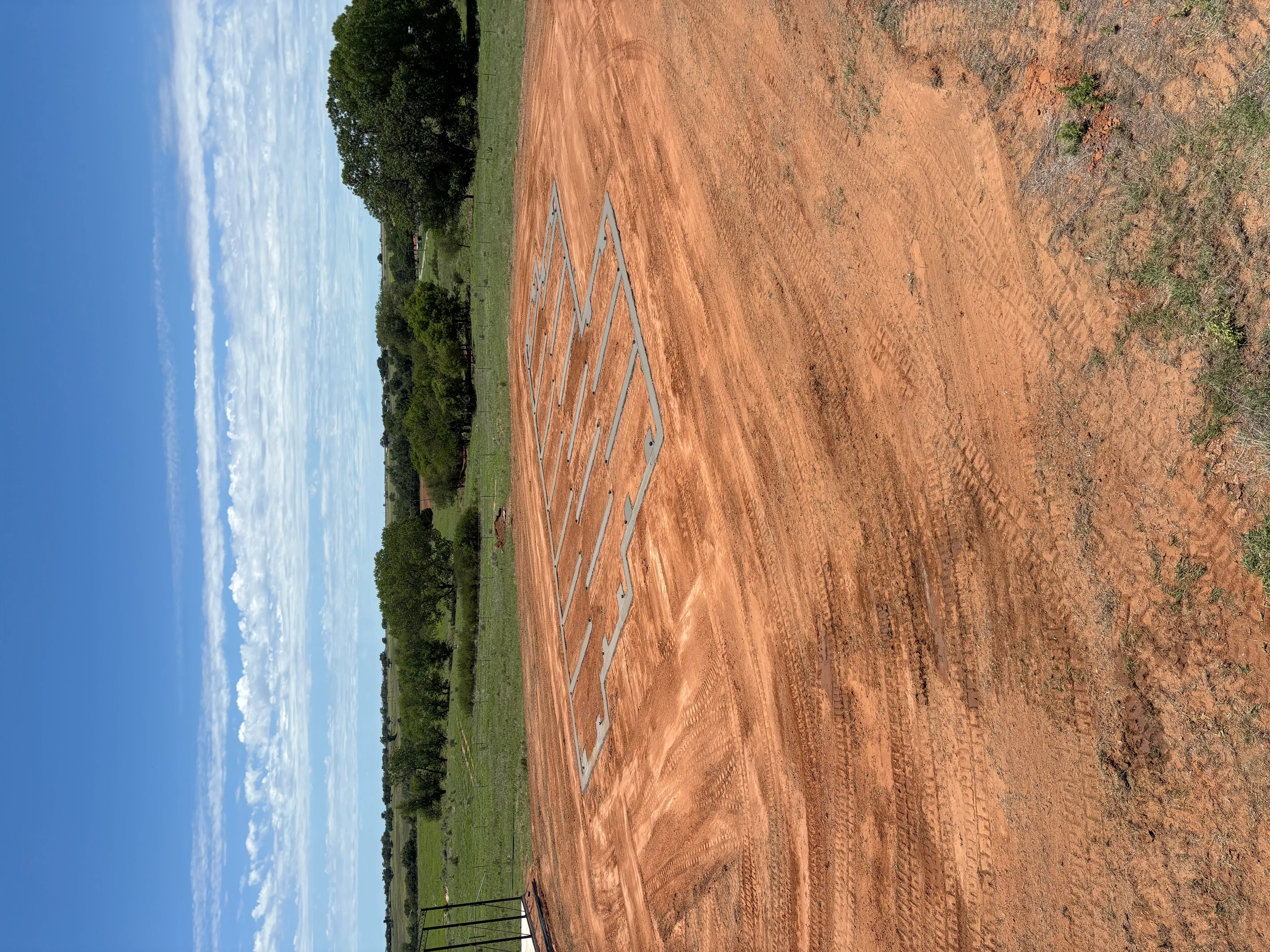 White chalk foundation layout lines on red clay soil with site grading and preparation